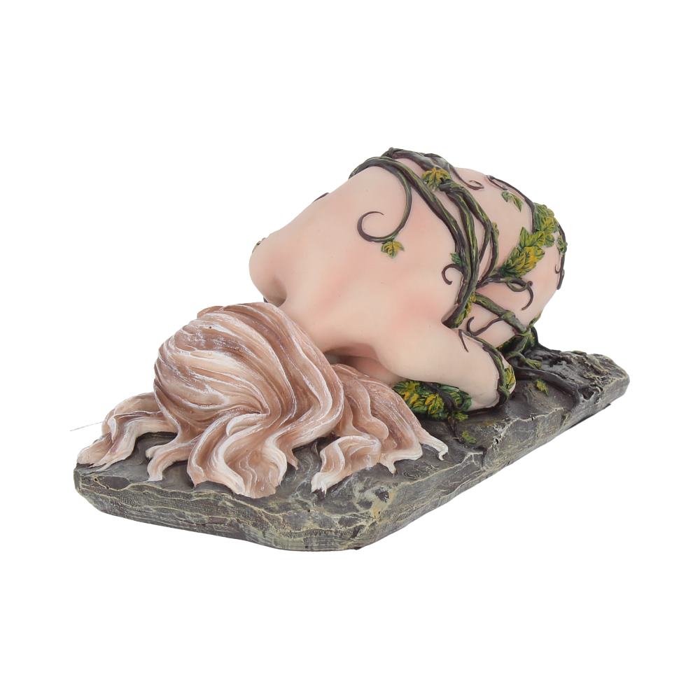 A small figurine of a person kneeling with head down, wrapped in vine-like patterns, rests on a textured base resembling stone. The figure features flowing hair and intricate detailing.