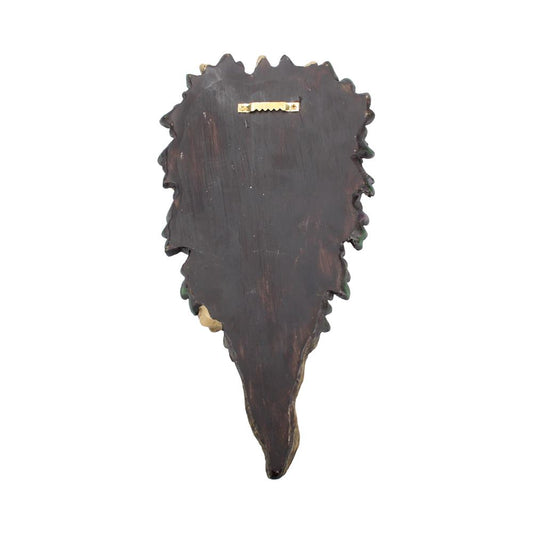 Wooden leaf-shaped wall plaque hangs by a small brass sawtooth hanger; dark stained with irregular serrated edges tapering to a point against a plain white background.