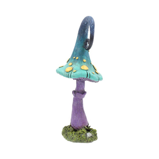 A whimsical mushroom sculpture rises, its turquoise cap dotted with yellow; a long blue-green stalk curls into a loop. Mossy base stands against a bright white background.