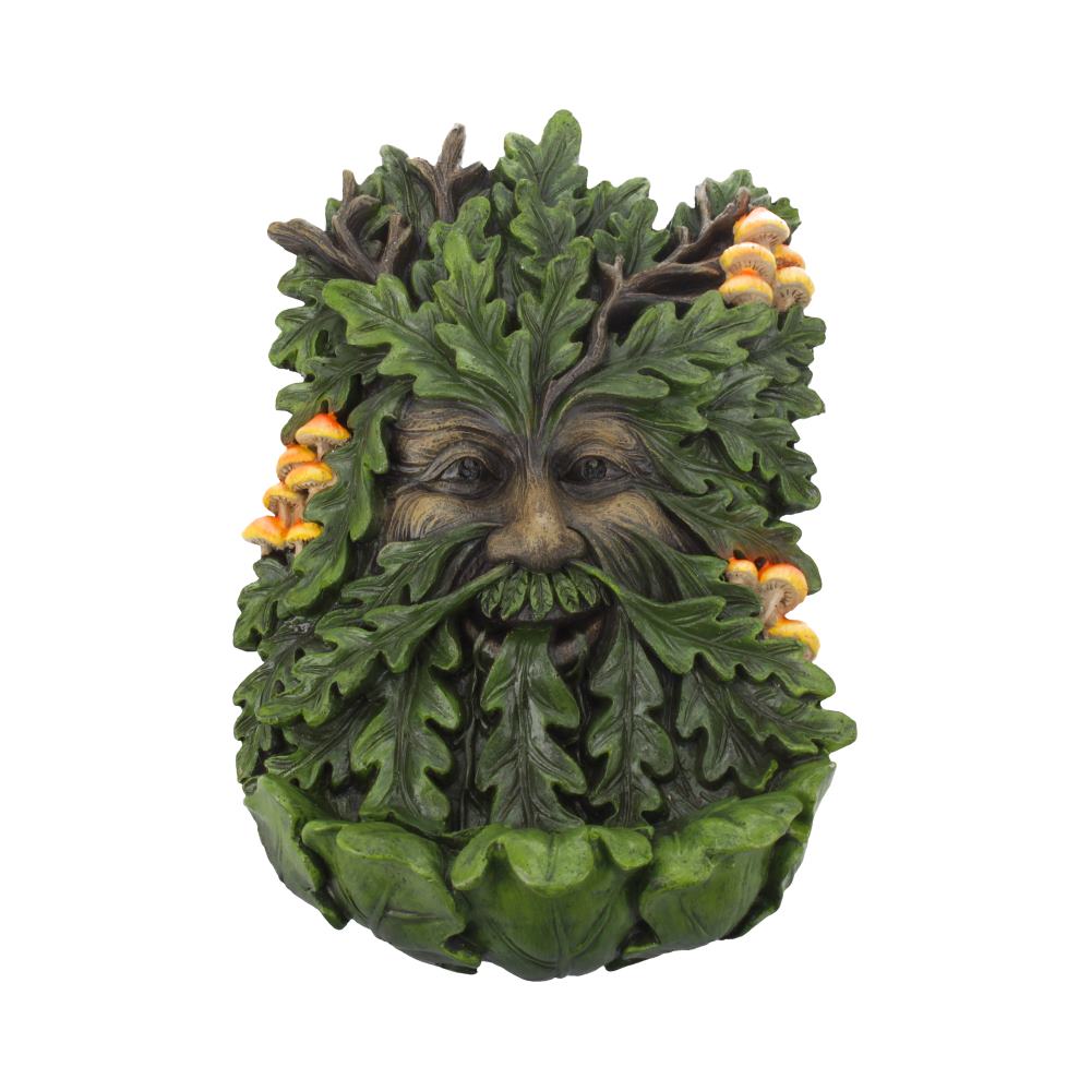 Leafy face sculpture with a human expression, featuring branches and orange mushrooms growing from it. The leaves are lush and layered, creating a green, forest-like appearance.