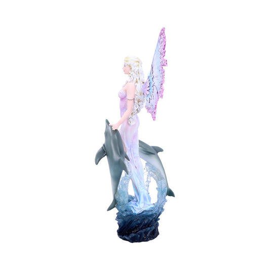 A fairy statue with pink butterfly wings stands with one hand on a dolphin, with another dolphin jumping behind, amidst sculpted ocean waves on a rocky base.