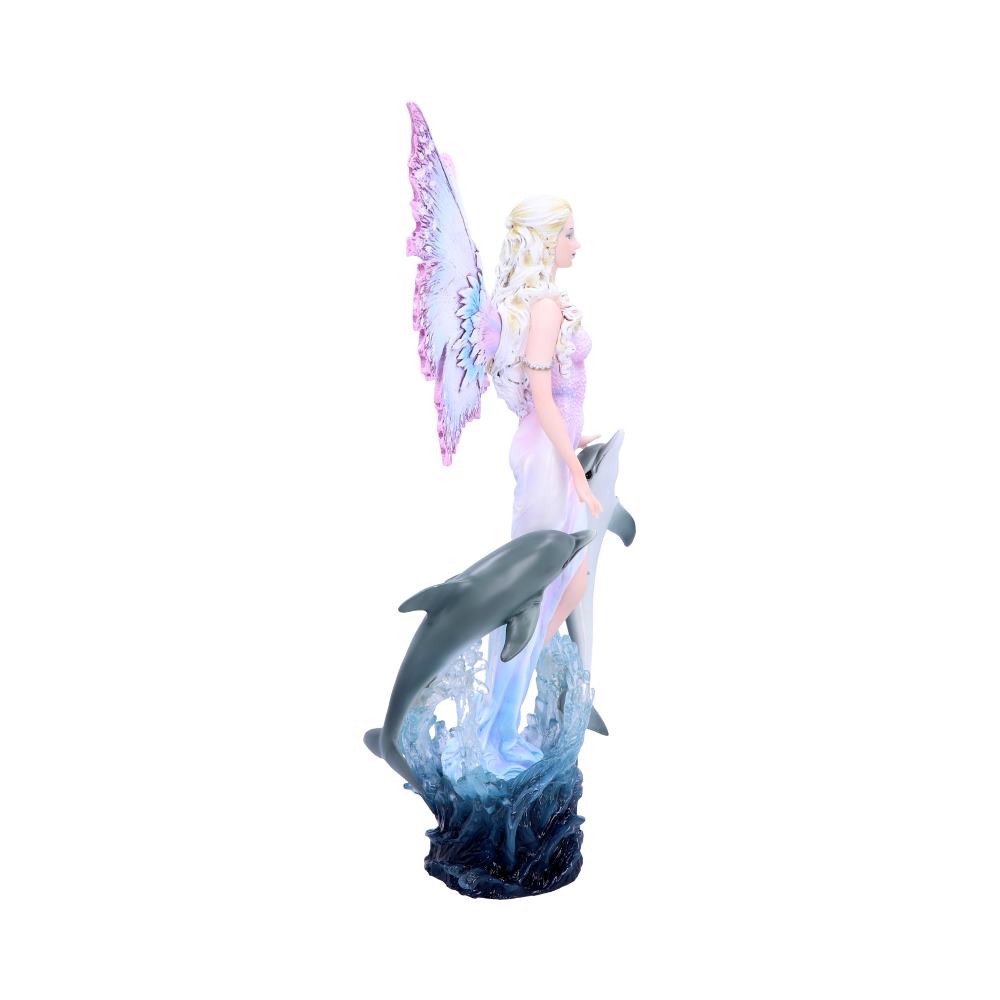 Fairy figurine stands in a wave, holding two dolphins. Her pink wings are outstretched. The background is white.