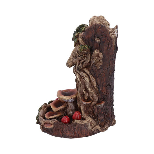 A detailed tree stump sculpture with prominent bark texture features intertwining roots. Mushrooms and red berries grow at the base, surrounded by small leafy vines, set against a plain backdrop.
