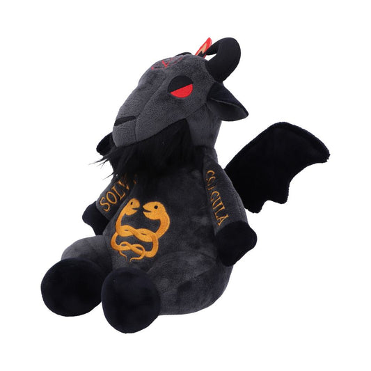 A plush toy resembling a dark goat with wings is seated upright. It features red eyes, a black beard, and embroidery. The words "SOLVE" and "COAGULA" are written on its arms, with two intertwined snakes on its torso.
