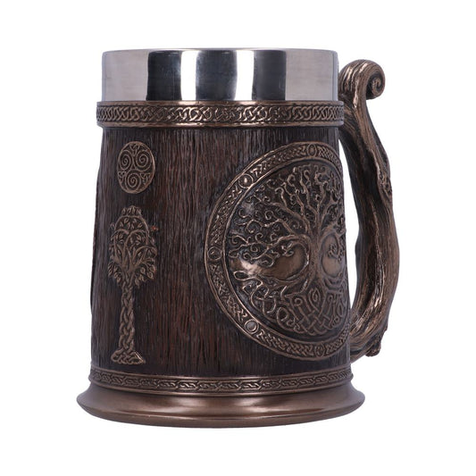 A stein sits against a white background. It is bronze-colored, with the image of a tree carved on the body and a wood-like handle. The top is silver.