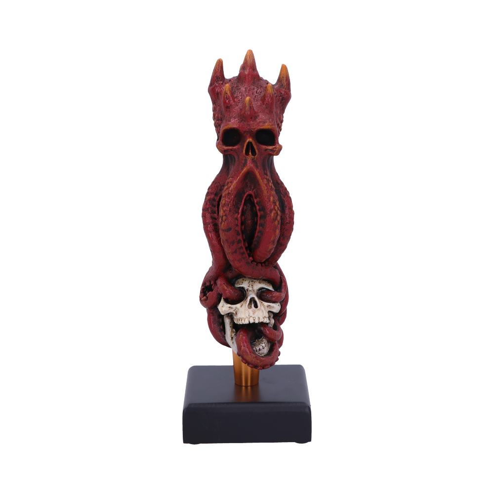 A red, tentacled sculpture with a crown-like top encloses a skull, perched on a black square base. Set against a plain white background.