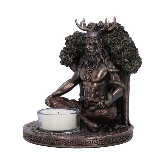 Bronze-toned figurine of a horned, bearded man seated cross-legged, holding a coiled snake and wearing pendants, backed by sculpted trees on a circular base with a glass tealight candle.
