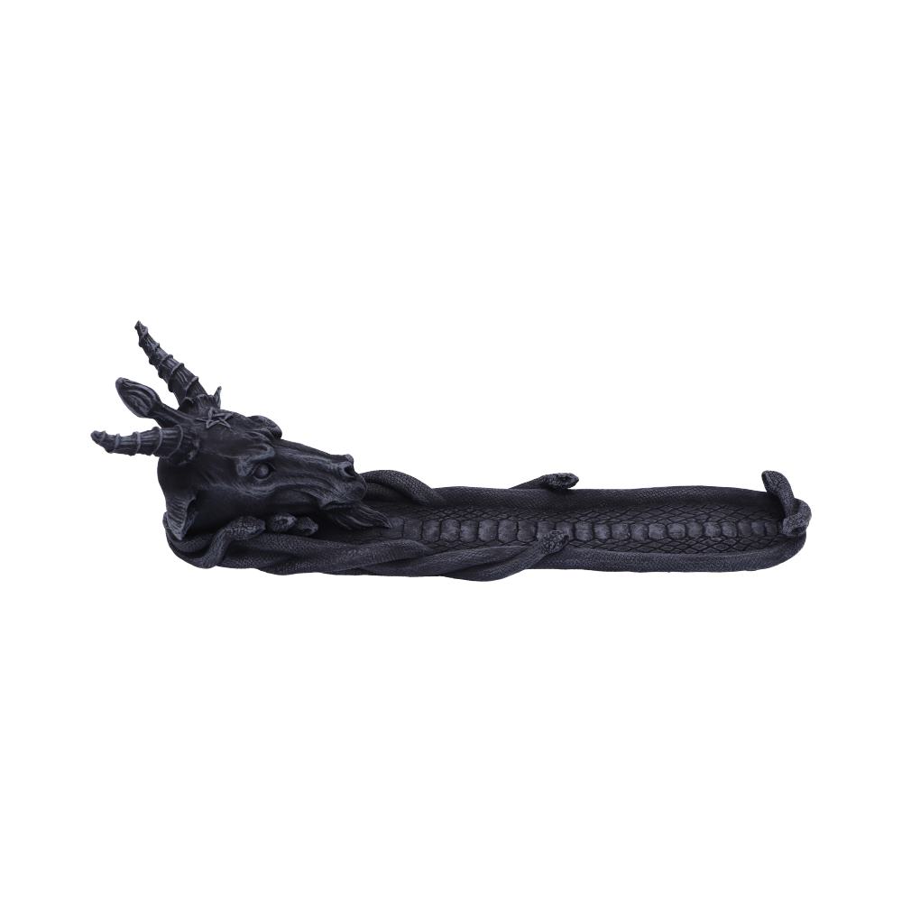 A dark, intricately designed incense holder featuring a goat-like head with horns and a long, braided, serpentine tail. It is set against a plain white background.