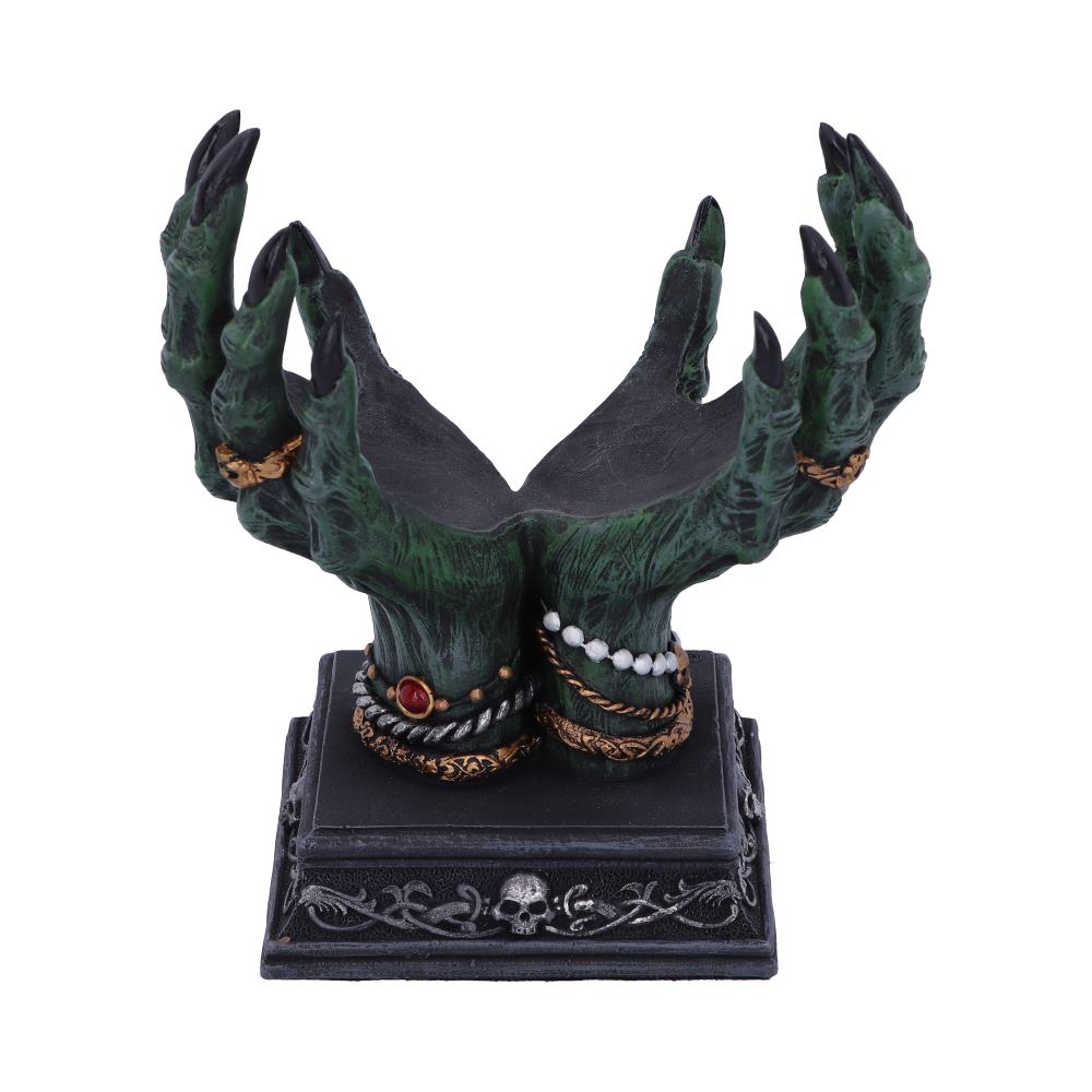 Two green, clawed, jeweled hands reach upward, creating a small bowl shape above a black pedestal base decorated with skulls, all on a white background.