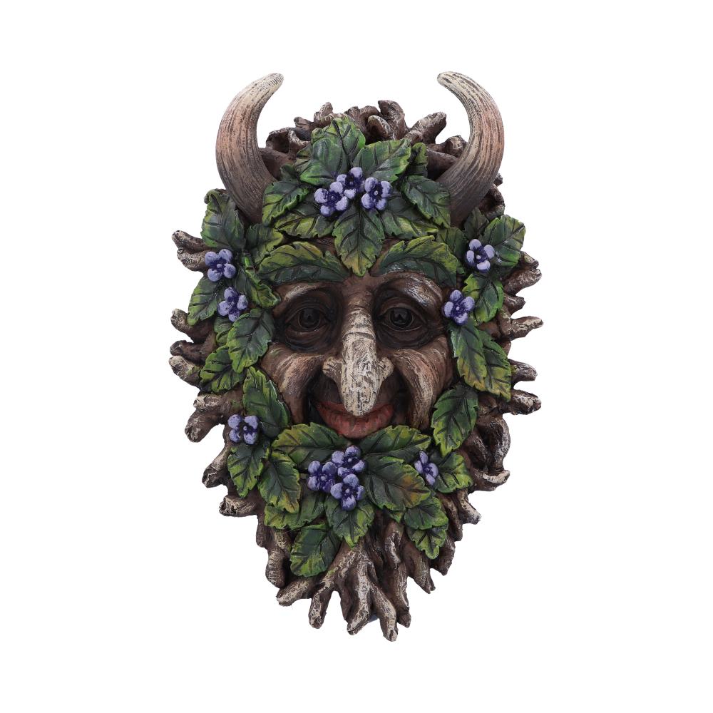 A decorative mask with horned features, adorned with leaves and purple berries, depicts a face in nature-themed design. The background is plain, highlighting the mask's detailed craftsmanship.