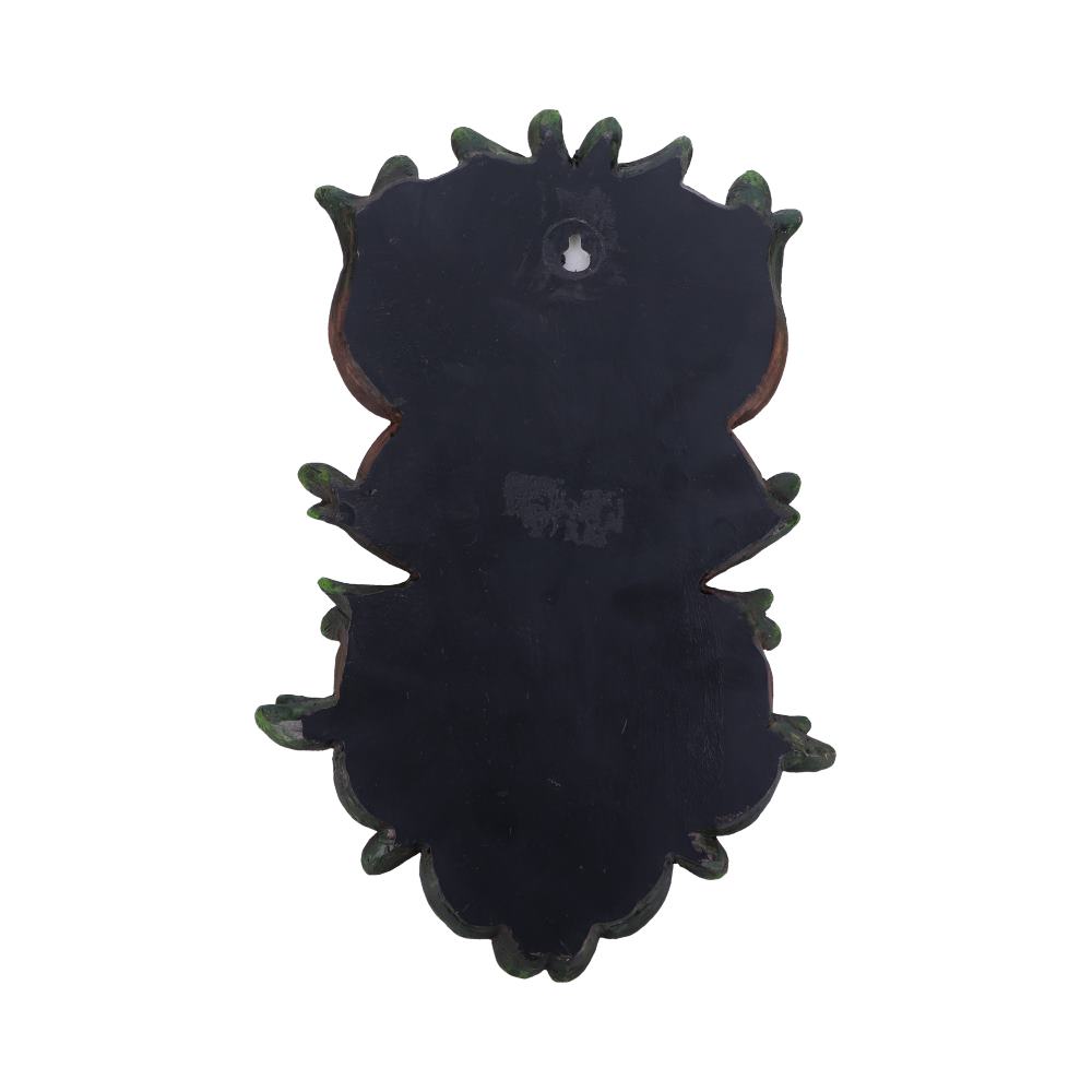 A black, ornate wooden plaque with a decorative scalloped edge, has a keyhole opening near the top for hanging, displayed against a plain white background.