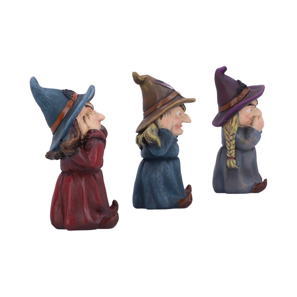 Three whimsical witch figurines stand side by side, each in distinct poses of covering their ears, eyes, and mouth, against a plain white background.