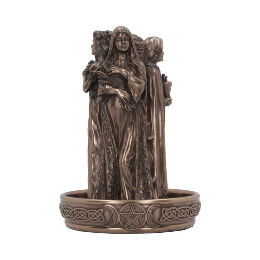 A bronze sculpture of three women stands on a circular base; the base is decorated with Celtic knotwork and a pentacle.  The central figure holds grain.