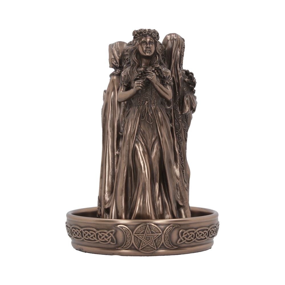 A bronze figurine depicts three women; a central figure, flanked by two others, stands on a circular base etched with Celtic knotwork and pagan symbols.