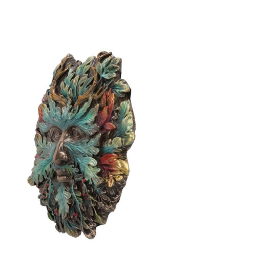 A decorative face mask with intertwined colorful leaves forms a vibrant, textured visage. The mask's expression appears serene, surrounded by a plain white background, suggesting it is a standalone art piece.