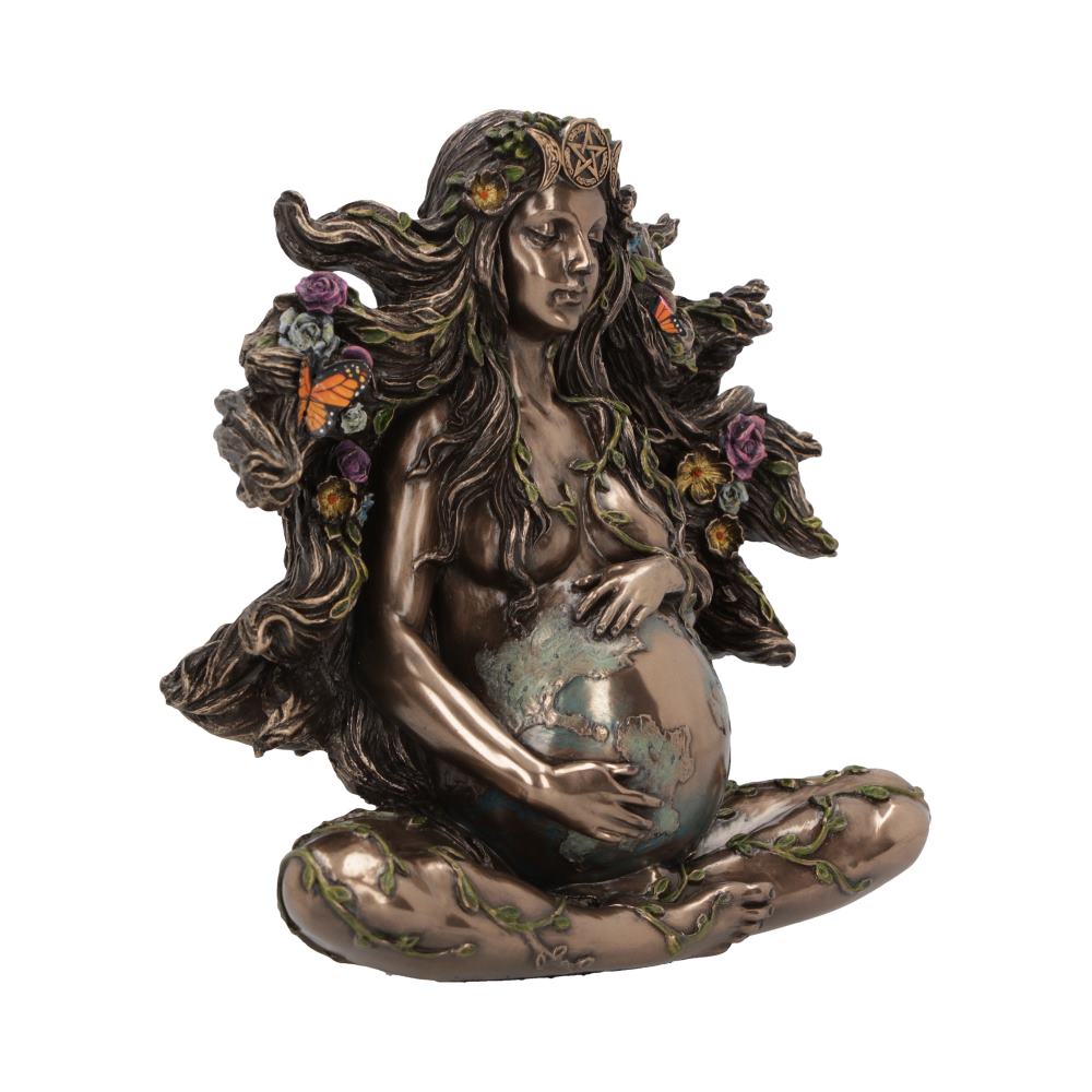 A bronze statue of a woman with flowing hair adorned with flowers and butterflies, holding a globe in her lap, surrounded by intricate vines.