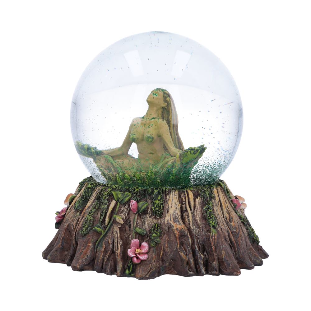 A female figurine sits cross-legged in a glass sphere atop a tree stump base, adorned with flowers and mushrooms.  The figurine appears to be made of a material resembling moss or lichen.