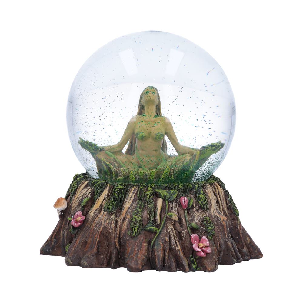 A female figurine sits in a lotus position inside a glass sphere;  it rests on a tree stump base, decorated with flowers and mushrooms.