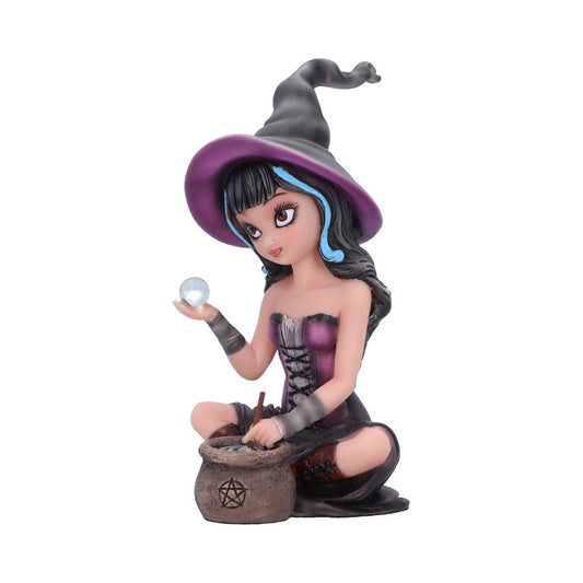 A figurine of a young witch kneeling, holding a crystal ball, and stirring a cauldron with a pentacle symbol, wearing a purple and black outfit with a pointed hat.