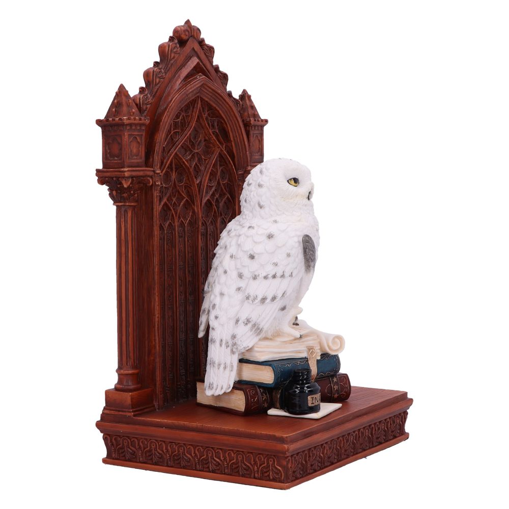 A white owl figurine perches on stacked books beside an ink pot labeled "INK," set against an ornate, carved, dark brown Gothic-style backdrop.