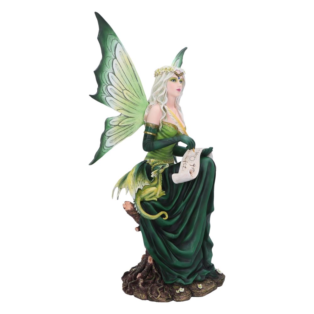A fairy with green wings sits on a tree stump, with a dragon at her side, holding a rolled parchment that has small drawings of the sun and other symbols on it.