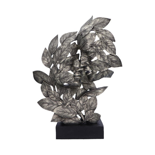 A metallic sculpture of intertwined leaves stands erect, supported by a rectangular black base, against a plain white background, showcasing intricate vein details on each leaf.