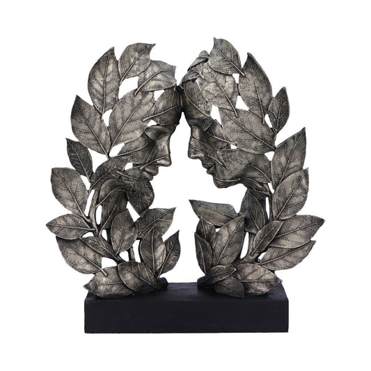 Two face sculptures composed of overlapping metallic leaves face each other on a black base, creating a symmetrical and artistic arrangement.