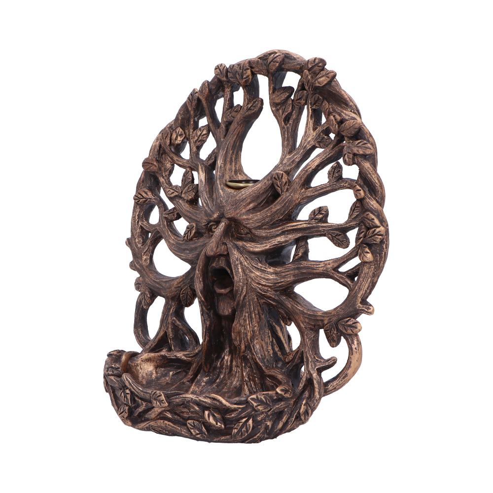 A carved, tree-shaped incense holder with a face in the trunk, branches forming its back, and leaves adorning the design; sits against a plain, white background.