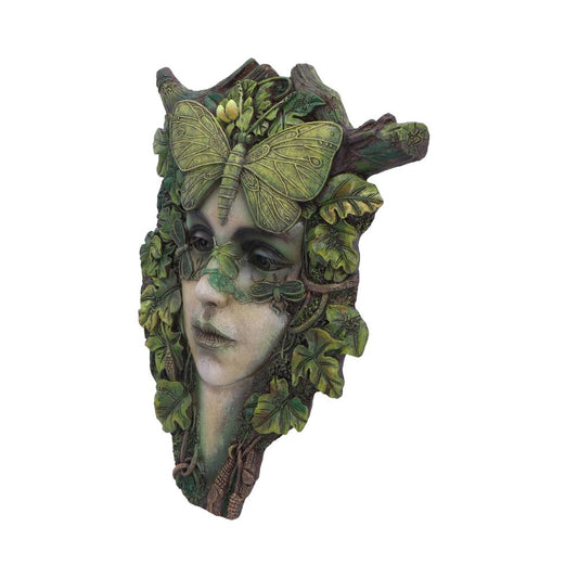 A sculpted face adorned with green leaves and twigs, featuring a prominent leaf butterfly on the forehead, creating an organic, nature-inspired appearance with a serene facial expression.