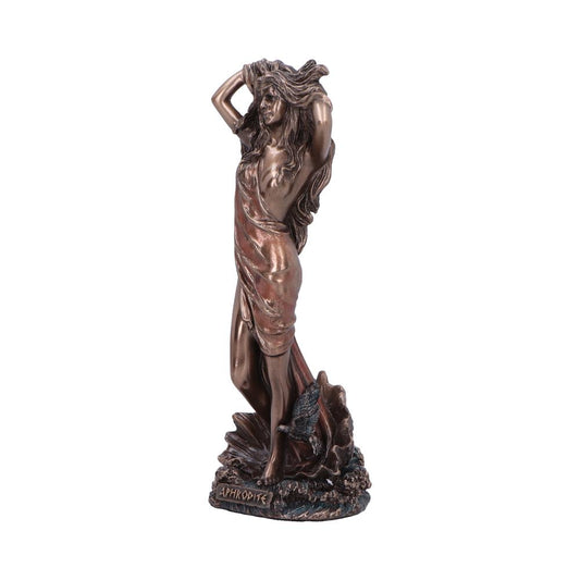A bronze statue depicts a woman standing, draped in a cloth, with both hands in her hair. It stands on a textured base with the text "ΑΦΡΟΔΙΤΕ."