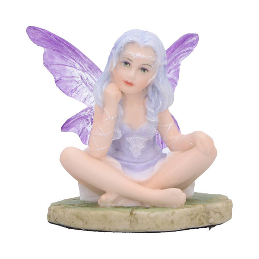 Small fairy figurine sits cross-legged, resting her chin on one hand, wearing a lavender dress with translucent purple wings and pale blue hair on a round mossy stone base