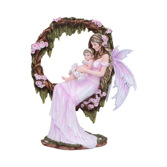 A winged fairy mother holds a swaddled infant while seated on a flowering crescent of bark and moss, wearing a flowing pink gown amid small pink blossoms.