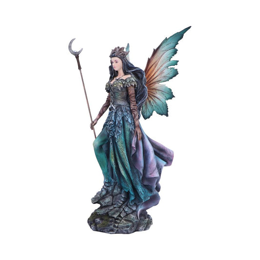 Winged fairy statue stands holding a crescent topped staff on a rocky base, wearing a teal and purple layered gown and crown, with large iridescent butterfly-like wings.