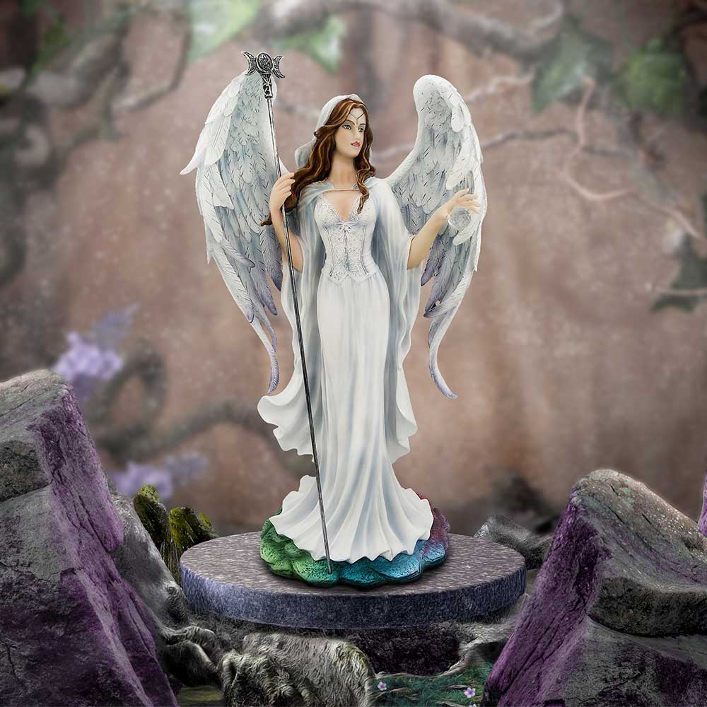 A white-robed female angel statue stands on a round pedestal, holding a staff with wings outstretched, hair flowing, set among mossy purple-tinged rocks and a blurred forest backdrop.