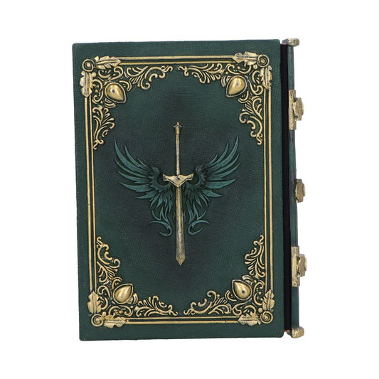Green leather-bound book displays a raised sword with outstretched wings emblem, ornate gold filigree border and corner motifs, closed and lying against a plain white background.