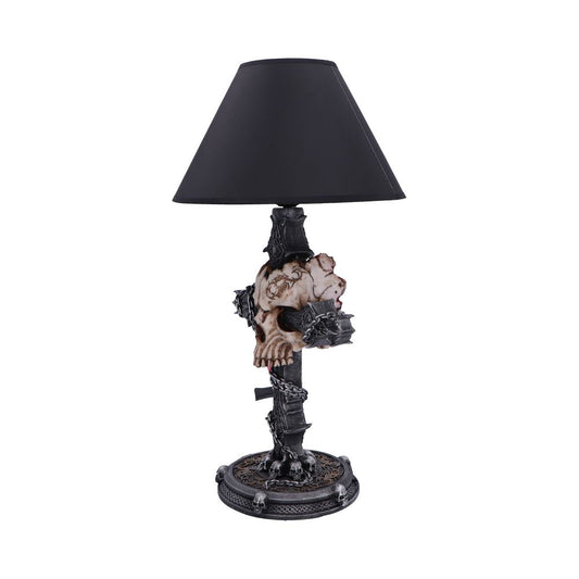 Gothic skull table lamp features a weathered skull mounted on a spiked column, wrapped in chains, topped by a black conical shade and set on an ornate skull-adorned base.