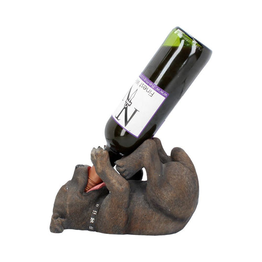 A dog statue lies on its back, holding a dark wine bottle; the bottle's label reads "Finest Wine www.nemesisn". The statue is isolated against a white background.