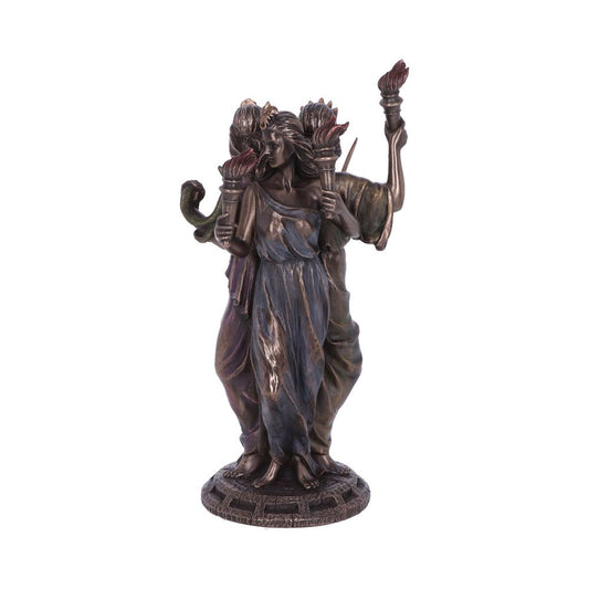 A bronze statue of a three-faced woman, each holding a torch, stands on a round textured base. The figures wear long, flowing robes, with a snake draped over one arm.