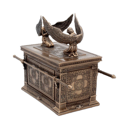 A bronze Ark of the Covenant stands alone. Two bronze angel statues kneel on its lid with wings spread. Ornate patterns decorate the sides and top.