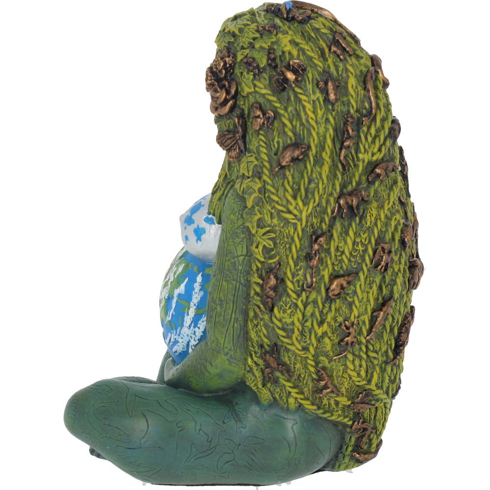 A figurine depicts a seated, earth-themed figure with green foliage-like hair adorned with small animals, cradling a globe. The setting is plain, emphasizing the figure's nature-inspired design.