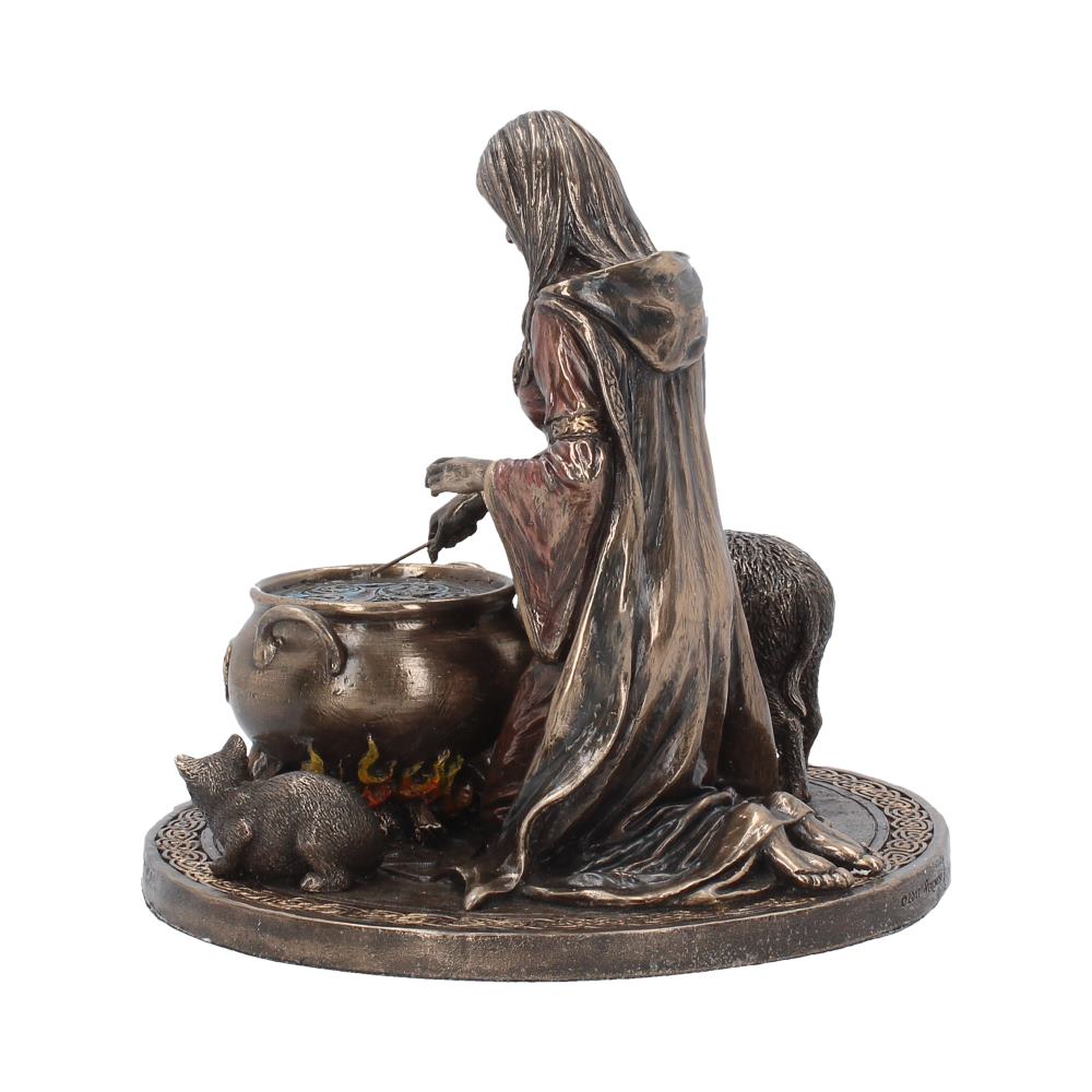 A robed figure stirs a bubbling cauldron over stylized flames, accompanied by animals on a decorative circular base, creating a mystical, medieval scene.