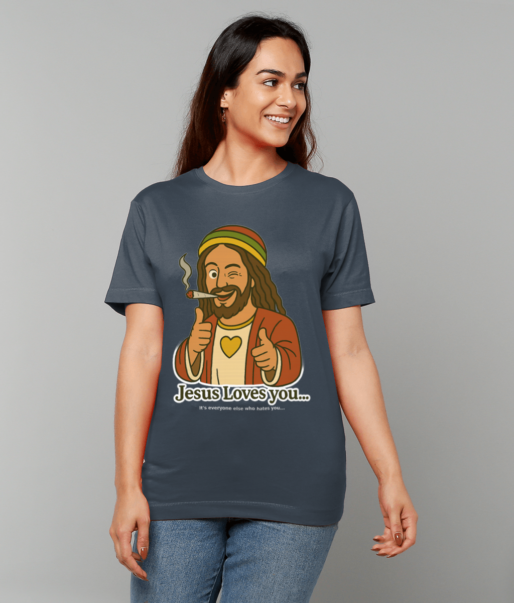 T-shirt graphic shows a winking, thumbs-up Jesus smoking a joint while a woman wears it against a plain gray background; text reads "Jesus Loves you... It's everyone else who hates you..."