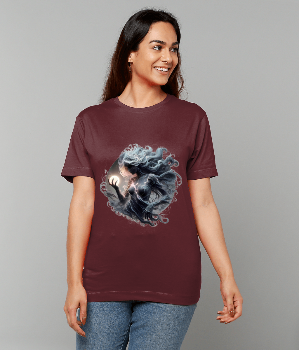 Woman wearing maroon T-shirt printed with a swirling ethereal figure holding a glowing orb, smiling and standing against a plain light-gray background.