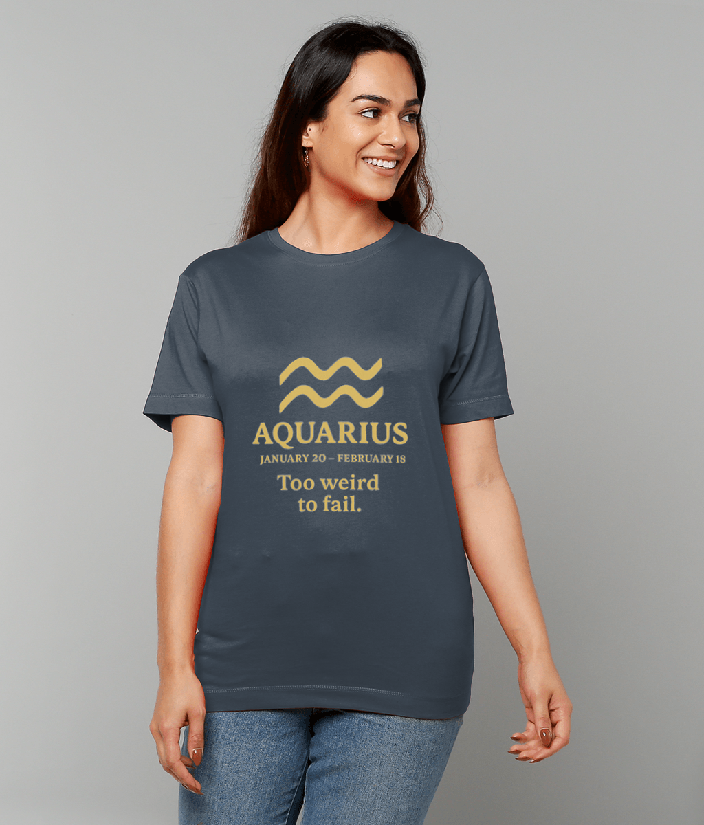 A navy T-shirt reading "AQUARIUS JANUARY 20 - FEBRUARY 18 Too weird to fail." worn by a smiling woman standing casually against a plain gray background.