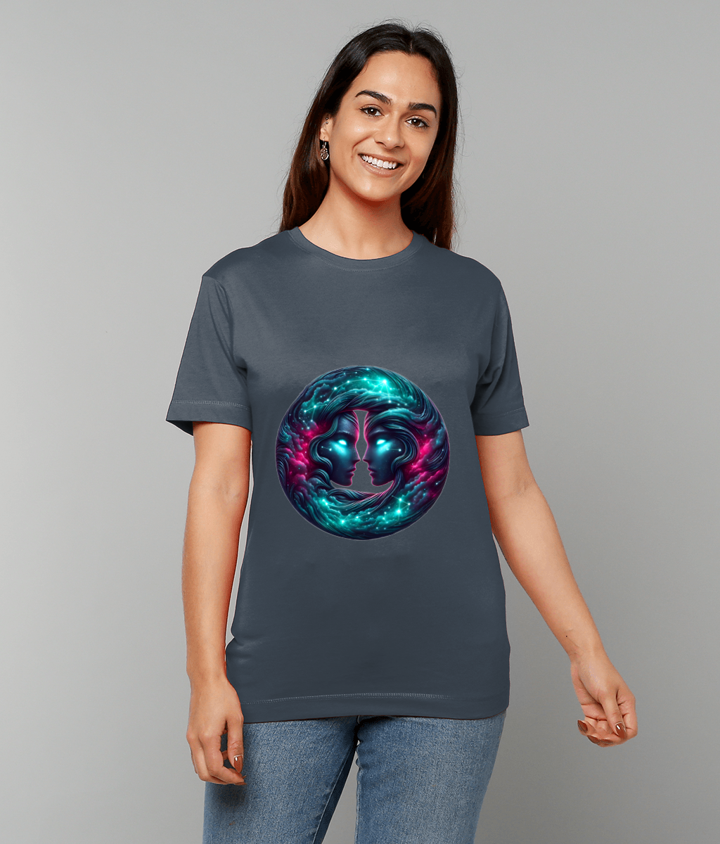 A woman smiles while wearing a gray T-shirt featuring a glowing circular cosmic design of two mirrored faces, standing casually against a plain light gray studio background.