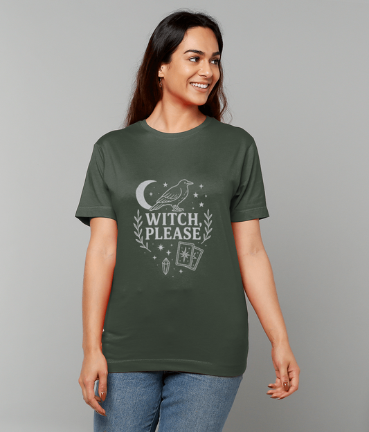 A green T-shirt displays a perched raven above the text "WITCH, PLEASE" with a crescent moon, stars, laurel branches, tarot cards and a crystal, worn by a smiling person against a plain gray background.
