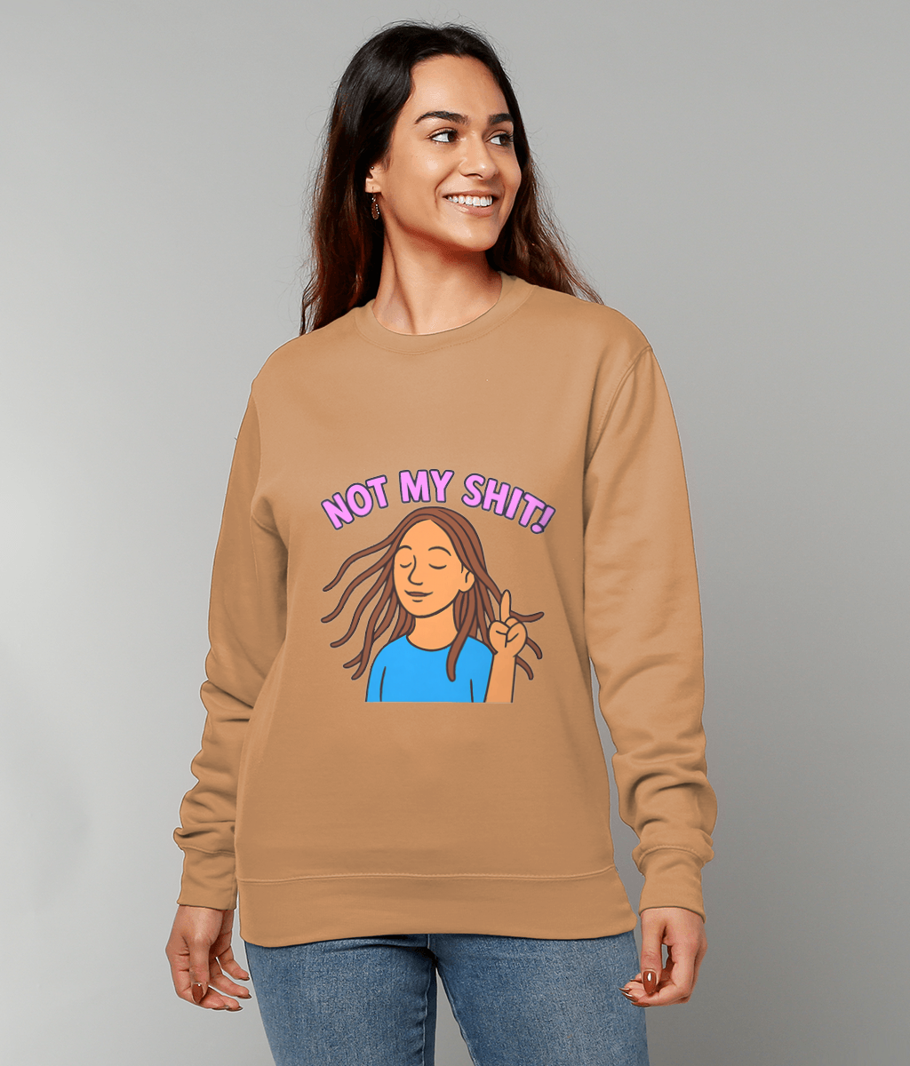 Tan sweatshirt reading "NOT MY SHIT!" featuring a cartoon woman flashing a peace sign, worn by a smiling person standing against a plain light gray background.