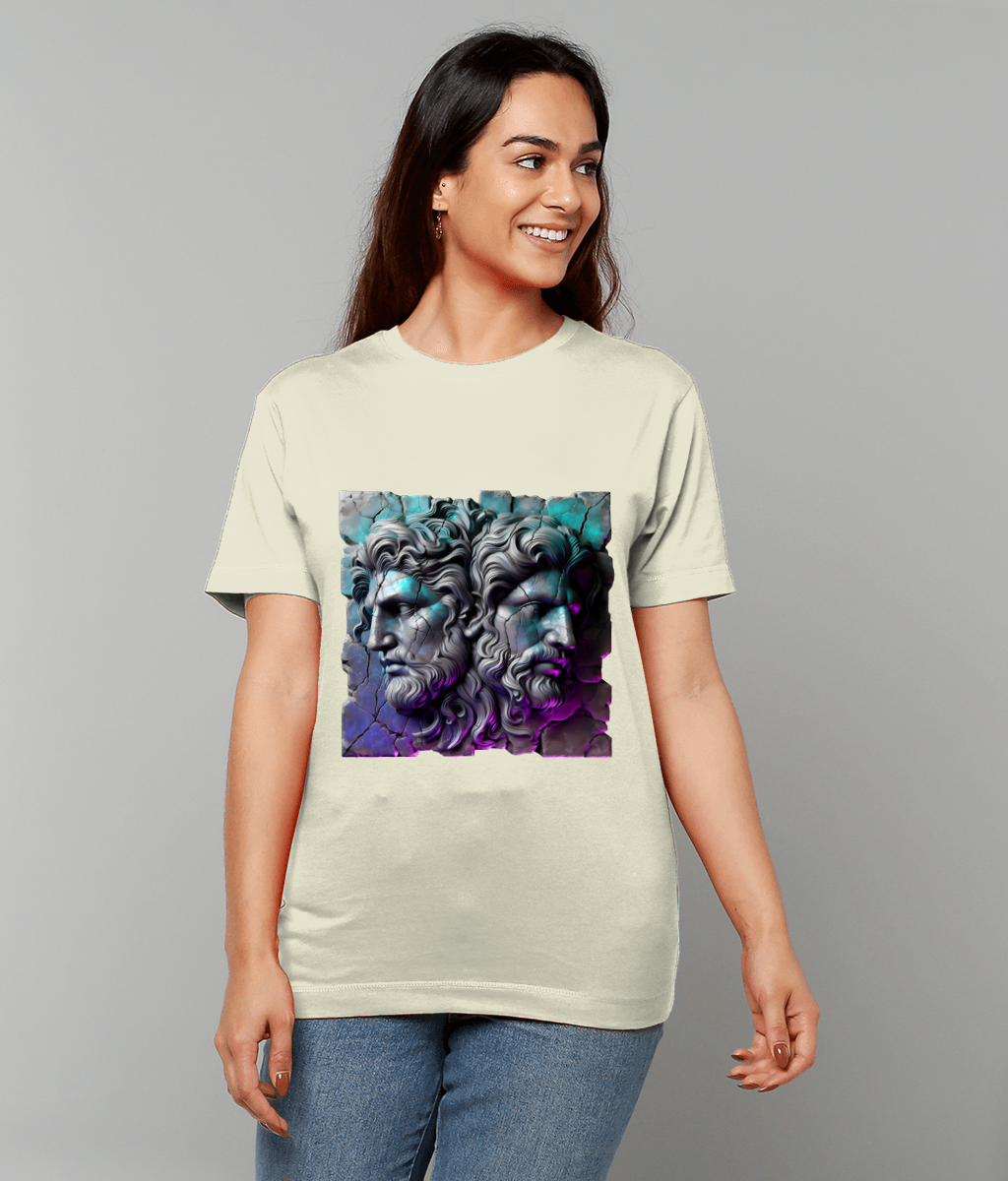 Cream T-shirt features a print of two classical stone male profiles back to back with teal and purple lighting; a smiling person wears it against a plain gray background.