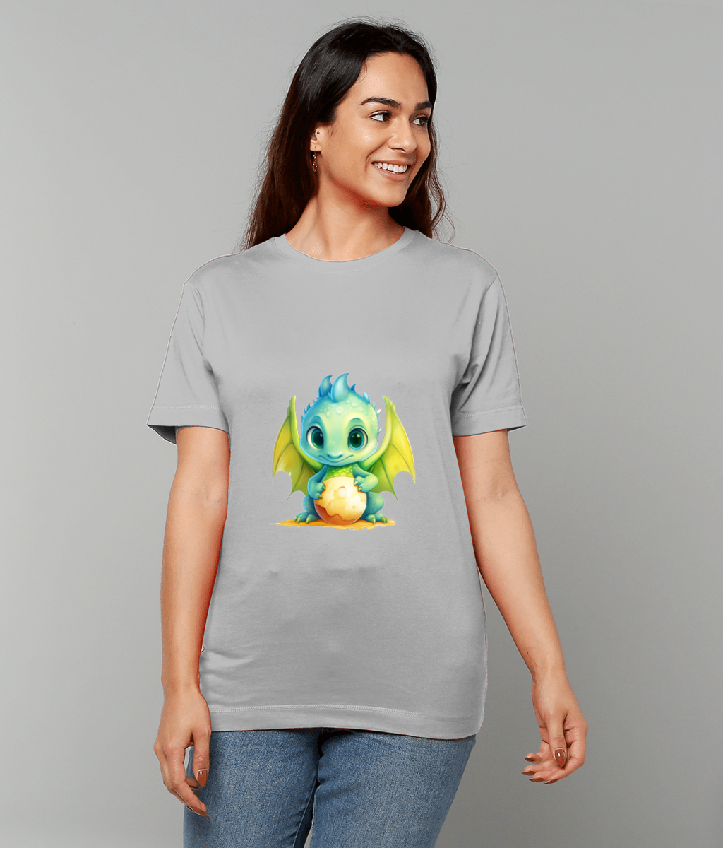 Light gray T-shirt displays a small green blue baby dragon cradling a glowing egg, worn by a smiling woman standing against a plain gray background.