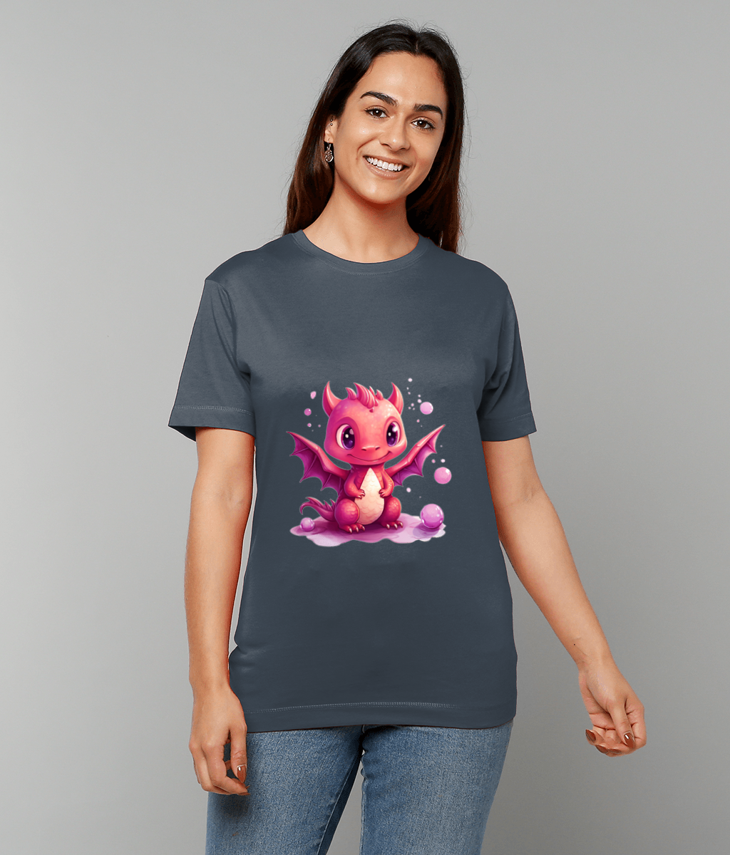 A pink cartoon baby dragon sits amid bubbles on a dark gray t-shirt worn by a smiling woman standing against a plain light gray background.